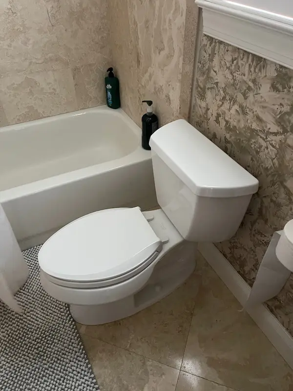everydayplumber-toilet-repair-installation Bathroom toilet installation and repair next to bathtub, showing updated plumbing fixture replacement for reliable use