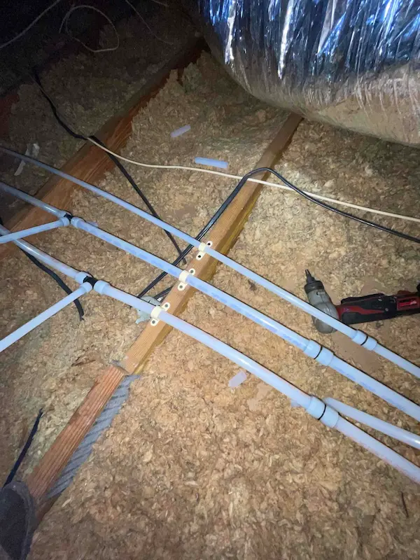 carrollwood-village-repipe-PEX-plumbing-installation Carrollwood Village attic repipe project with new PEX water lines secured along joists, replacing old plumbing for improved reliability and flow